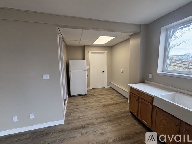 A kitchen with a white fridge and wooden cabinets.
