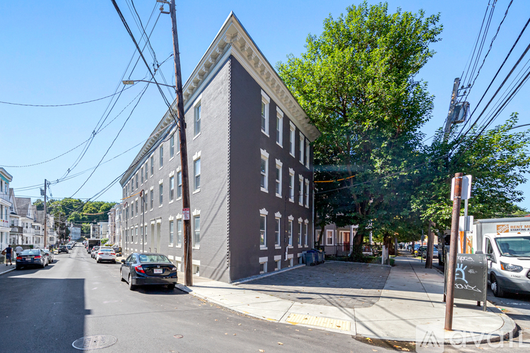 A street view of a building with cars parked on the side of the road.