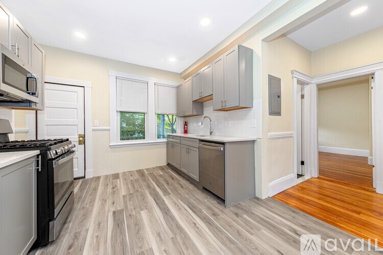A kitchen with wooden floors and white appliances.
