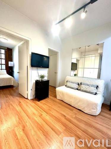 A living room with a white couch and a television.