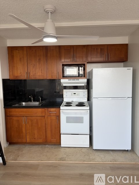 A kitchen with a white fridge, stove and oven.