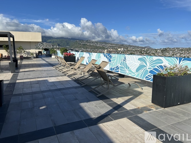 A rooftop patio with a pool and chairs.
