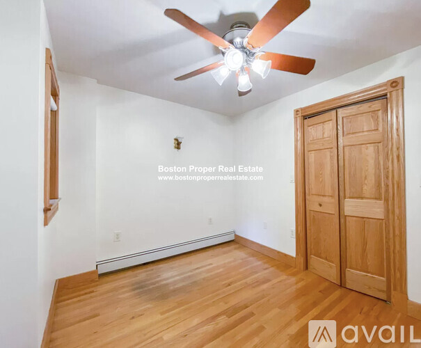 A room with a ceiling fan and wooden flooring.