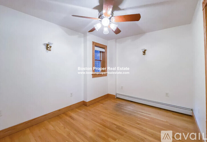 A room with wooden flooring and a ceiling fan.