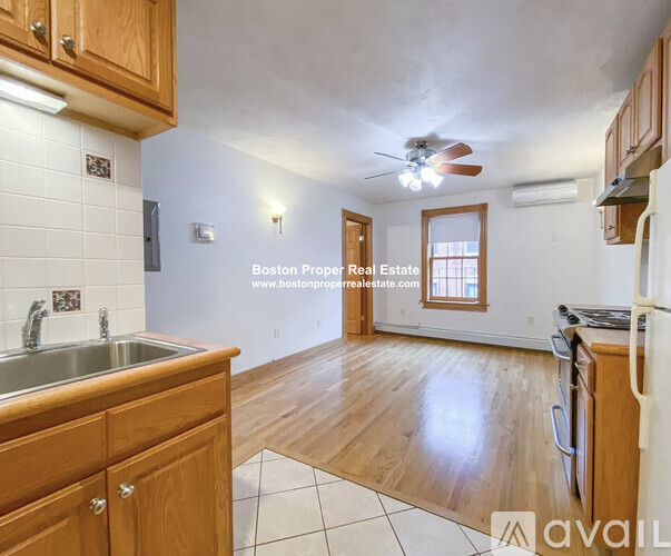 A kitchen with wooden cabinets and a white tile floor.