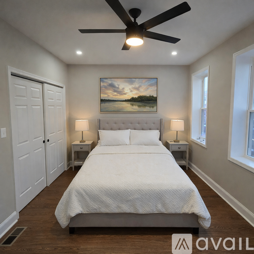A bedroom with a large bed and a ceiling fan.
