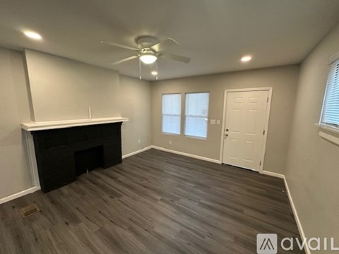 A room with a fireplace and wood flooring is available for rent.