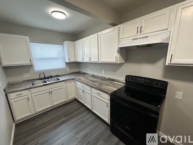 A kitchen with white cabinets and a black oven.