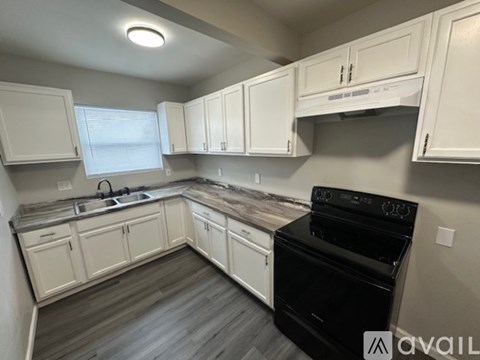 A kitchen with white cabinets and a black oven.