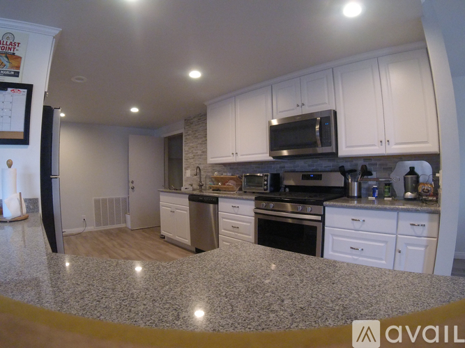 A kitchen with granite countertops and white cabinets.