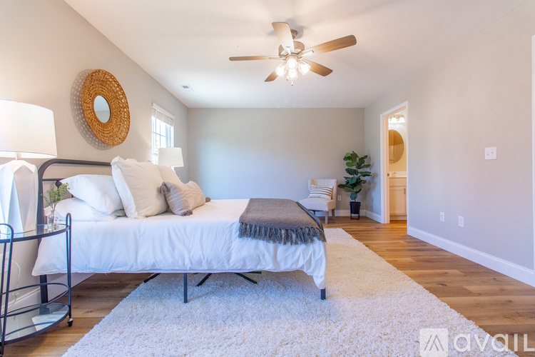 A bedroom with a bed, a ceiling fan, and a rug.