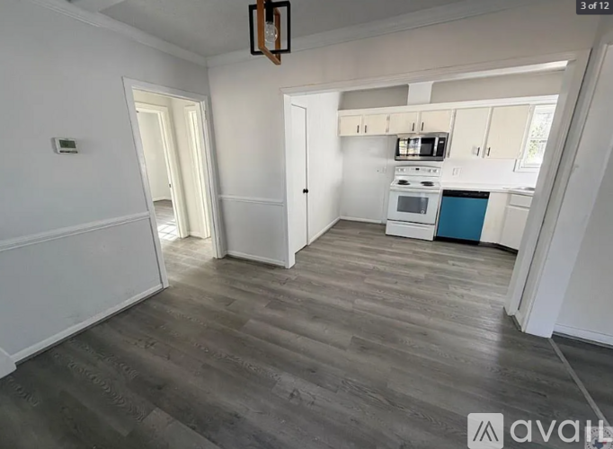 A kitchen with a blue counter and wooden floors.