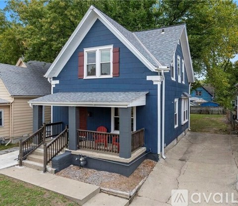 A blue house with a porch and a red chair.