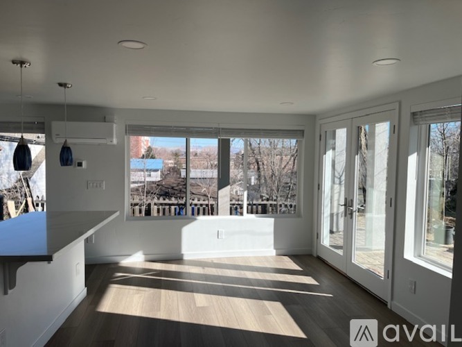 A sunny day in a spacious room with a view of a snowy landscape outside.