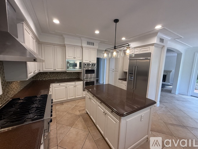 A kitchen with white cabinets and a brown countertop.