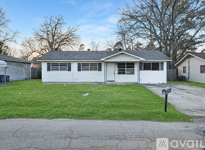 A house with a white siding and a grey roof is for sale.
