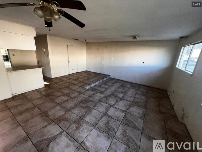 A room with a ceiling fan and tile flooring.