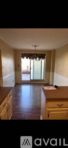 A kitchen with wooden floors and a large window.