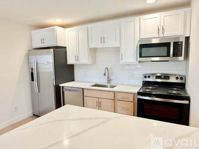 A kitchen with white cabinets and a black stove top oven.