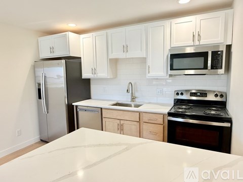 A kitchen with white cabinets and a black stove top oven.