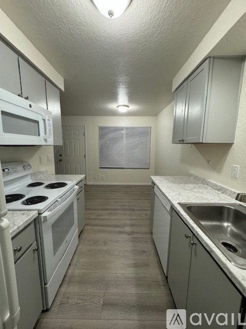 A kitchen with white appliances and cabinets.