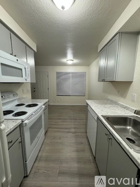 A kitchen with white appliances and cabinets.