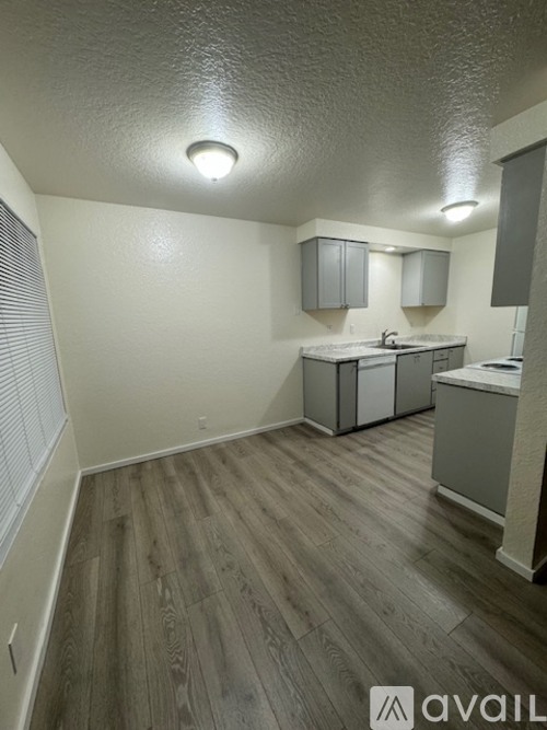 A bathroom with a sink, toilet, and cabinets.