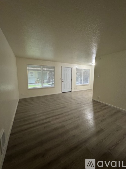 A room with wooden flooring and white walls.