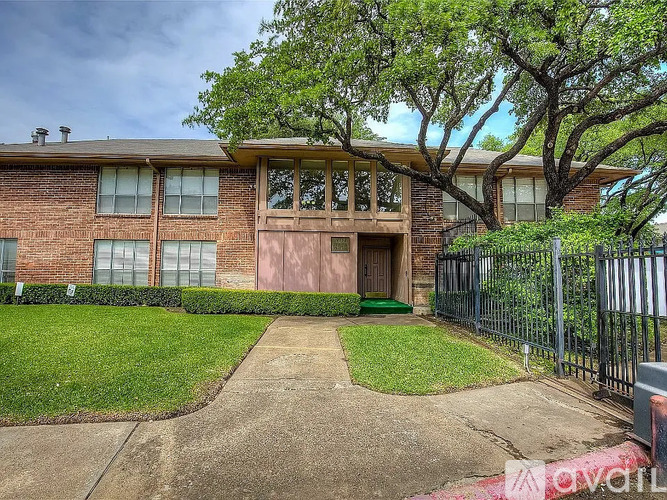A brick house with a green lawn in front.