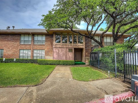 A brick house with a green lawn in front.