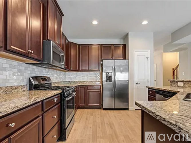 A kitchen with brown cabinets and a granite countertop.