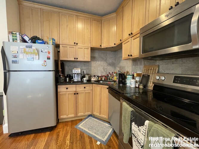 A kitchen with wooden cabinets and a refrigerator.