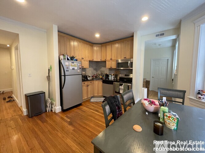 A kitchen with wooden cabinets and a black table.