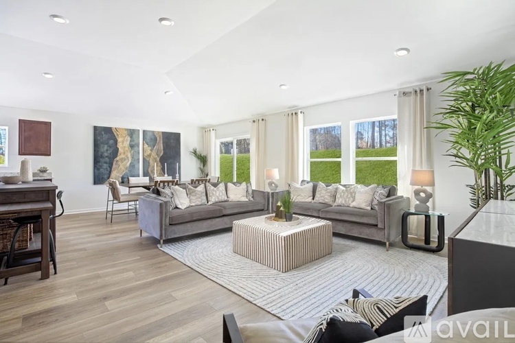 A modern living room with a grey sofa set and a wooden floor.