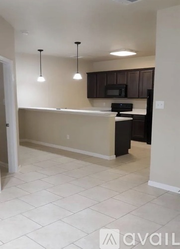 A kitchen with a white tile floor and a black counter.