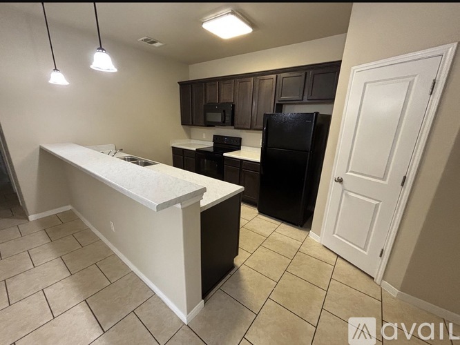 A kitchen with a white counter and black appliances.