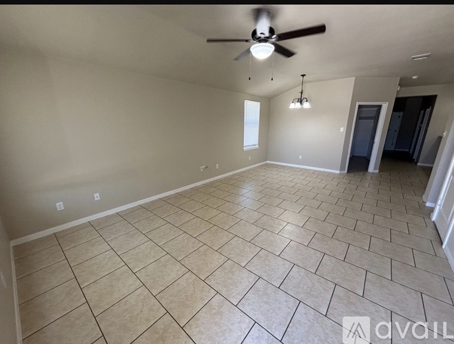 A spacious room with a ceiling fan and tiled flooring.