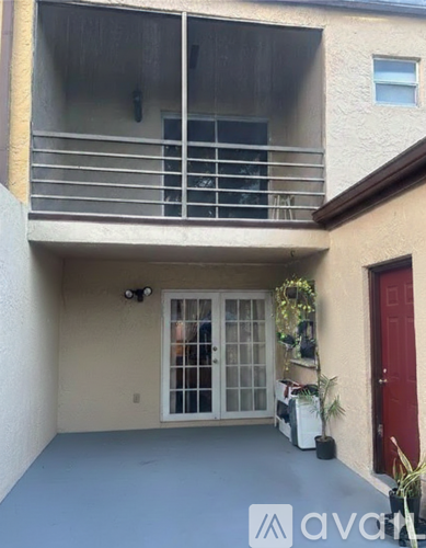 A balcony with a red door and a camera mounted on the wall.