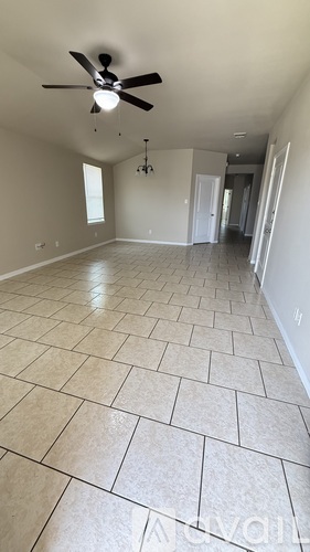 A spacious room with a ceiling fan and tile flooring.