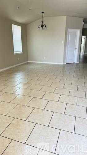 A living room with a tiled floor and a chandelier.