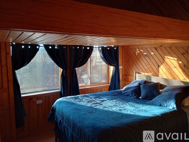 A bedroom with a bed and a window with curtains.