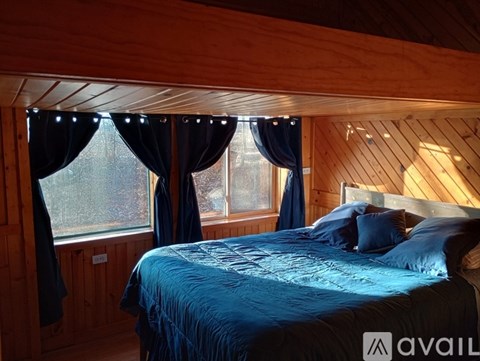 A bedroom with a bed and a window with curtains.