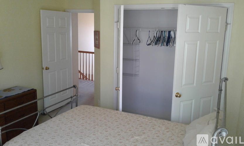 A bedroom with a bed, a closet, and a dresser.