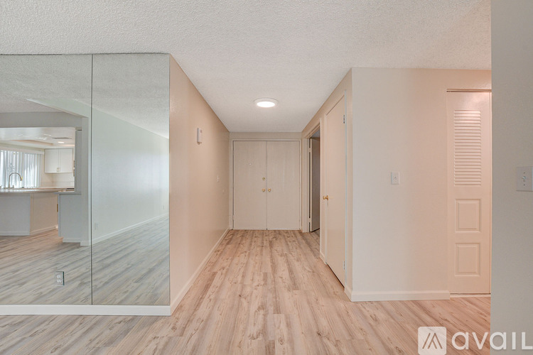 A room with wooden floors and a glass wall leading to a balcony.