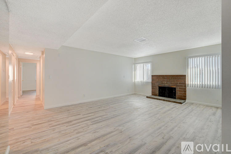 A spacious living room with a fireplace and wooden flooring.