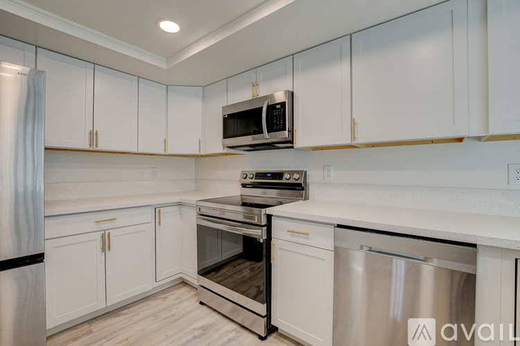 A kitchen with white cabinets and a black fridge.