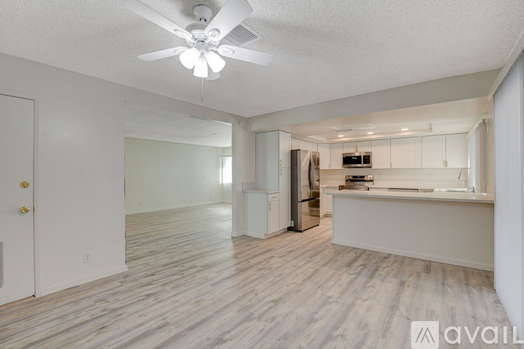 A spacious room with a fan and wooden flooring.