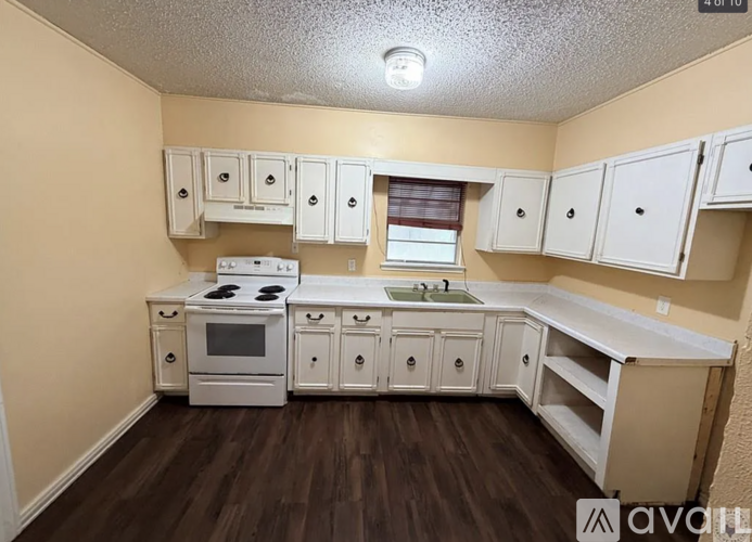 A kitchen with white appliances and cabinets.