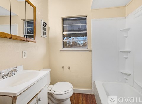 Empty room with wooden floor and white door.