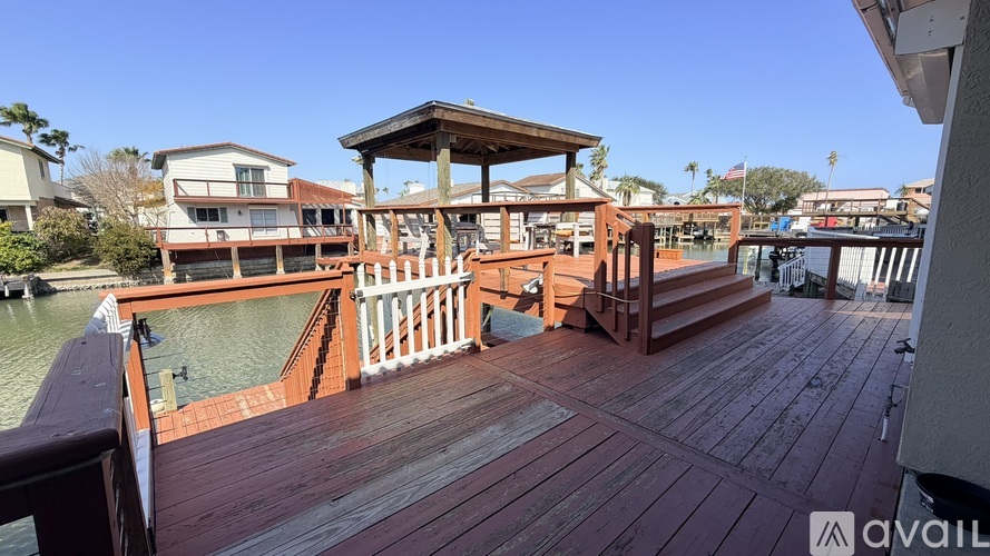 A wooden deck with a gazebo and a small pool.